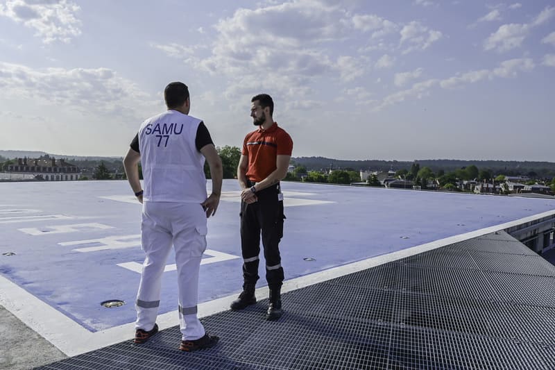 Ambulancier et agent de sécurité sur l'héliport de l'hôpital